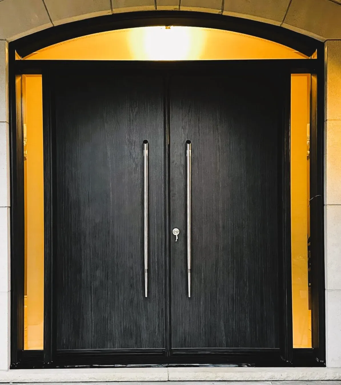 Dark wood double entry doors with sidelights and arched transom on a Bradford area home